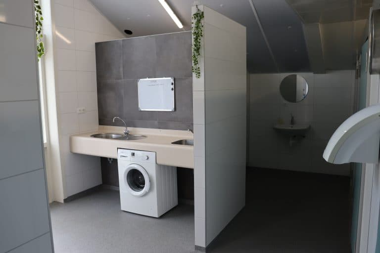 Wasruimte met wasmachine in het toiletgebouw
